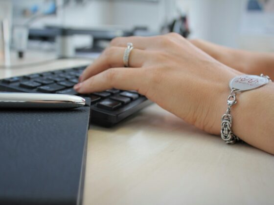 person wearing silver ring using black computer keyboard