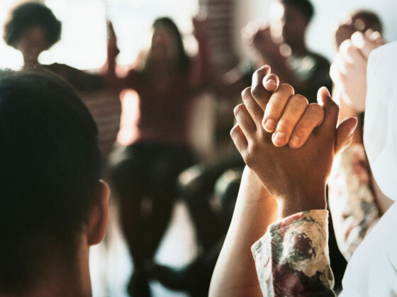 Group of people holding hands up in the air in rehab center in florida