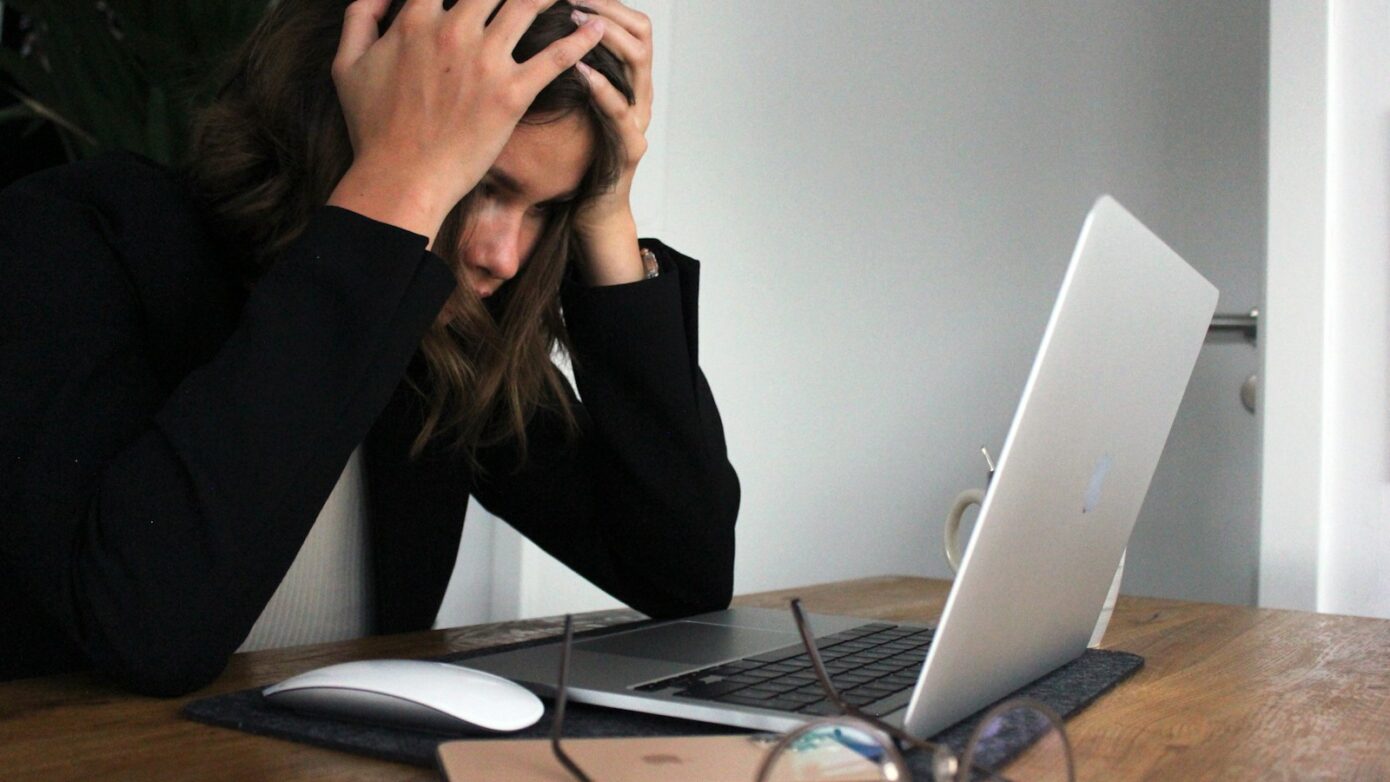 a woman sitting in front of a laptop computer